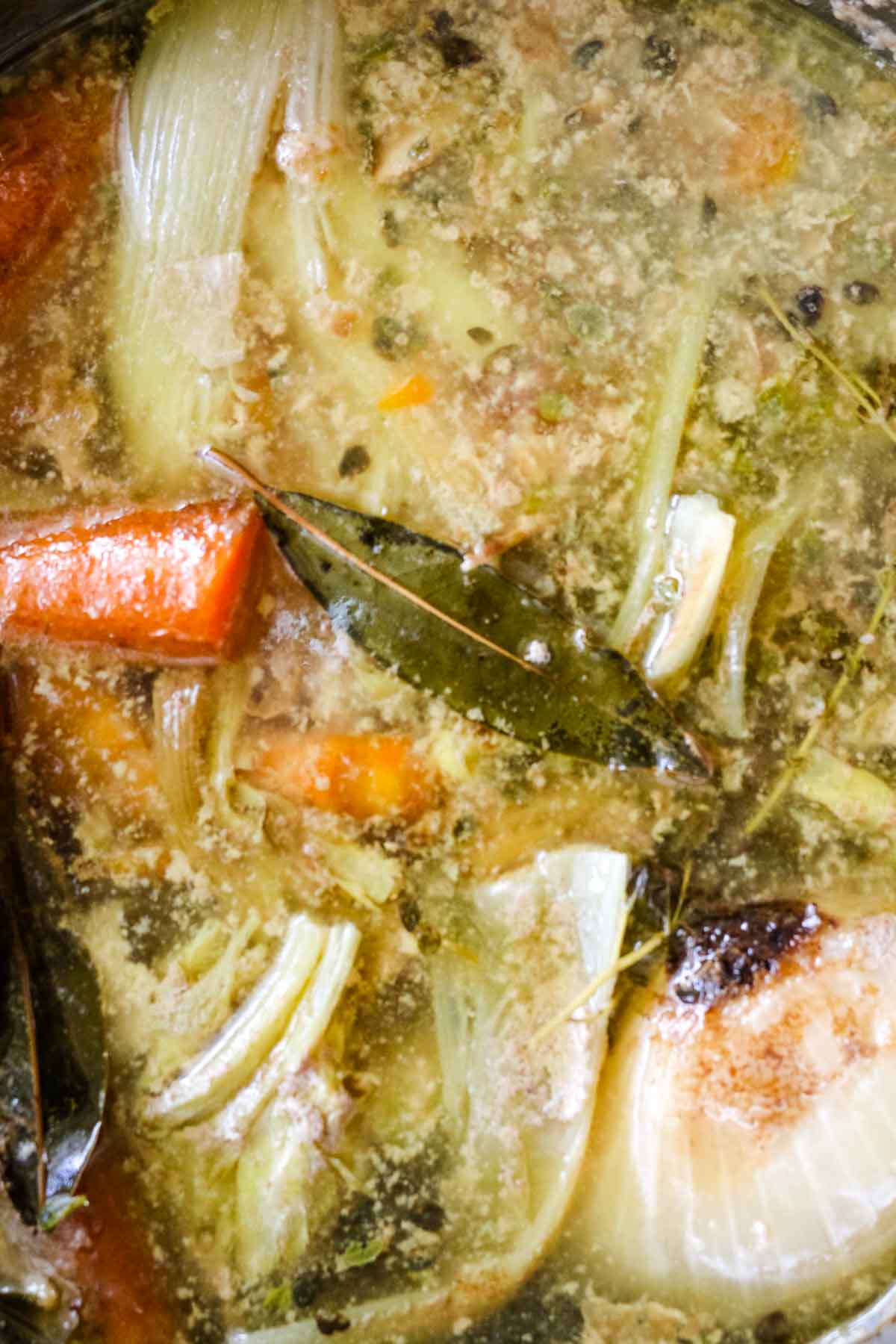 cooked broth with bay leaves and carrots.