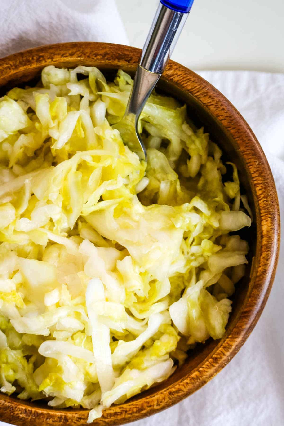 sauerkraut in wooden bowl with fork.