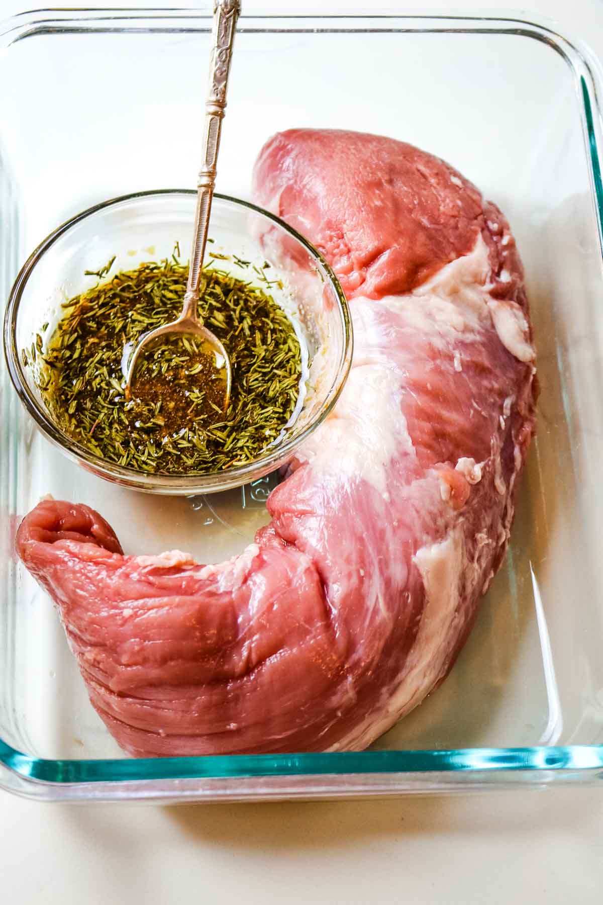 pork tenderloin with bowl of marinade.