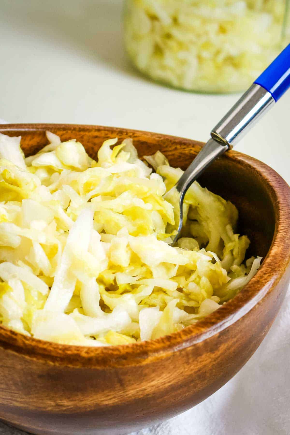sauerkraut in wooden bowl with fork.