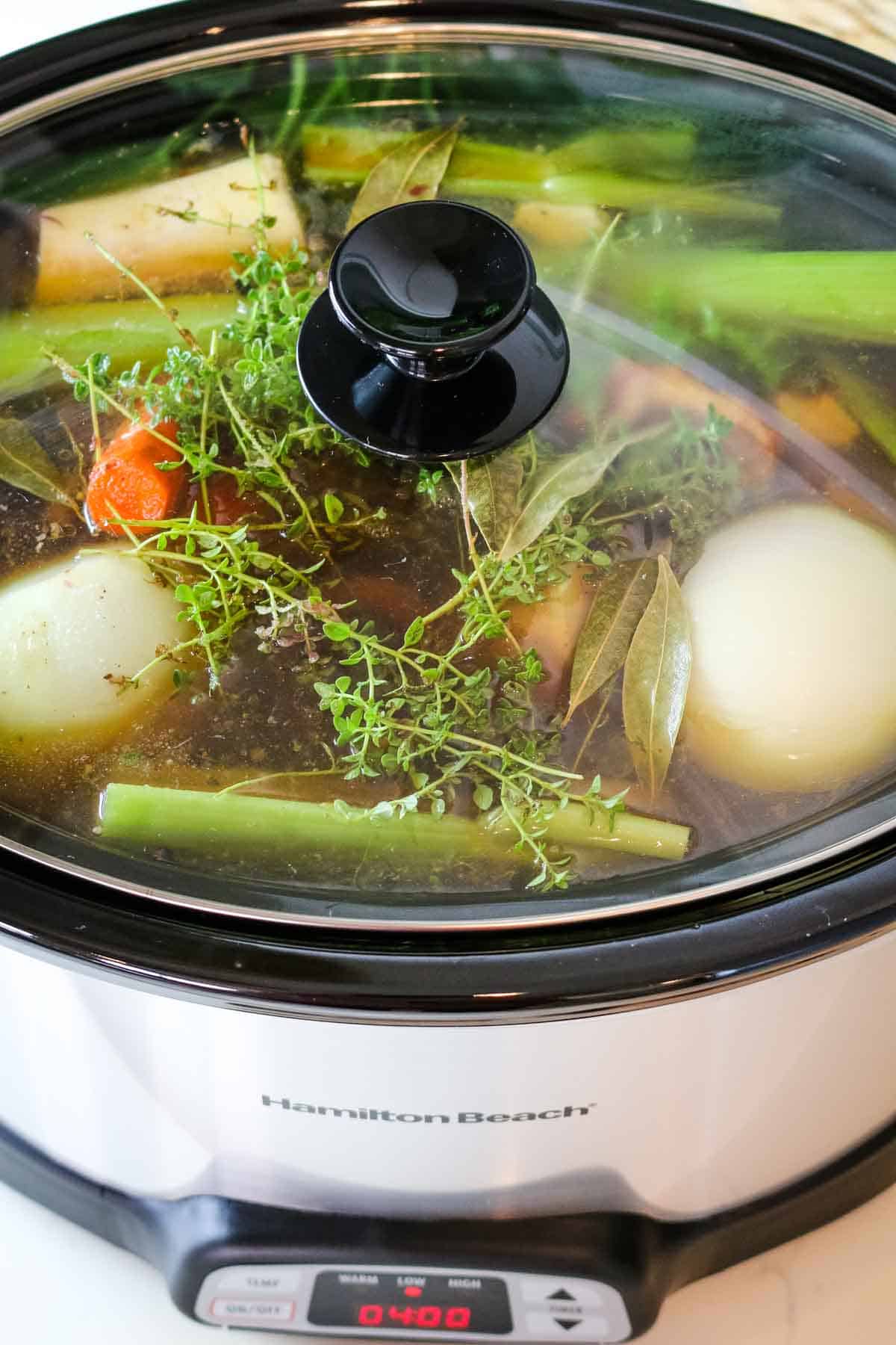 closed slow cooker with vegetables.