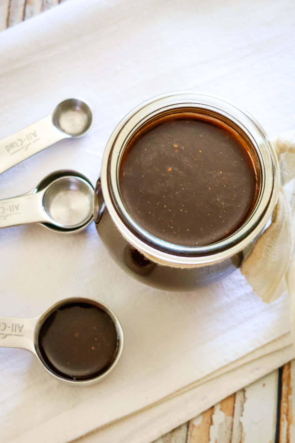 measuring spoons and small jar of dark sauce