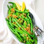 green beans with sauteed garlic and lemon wedges.