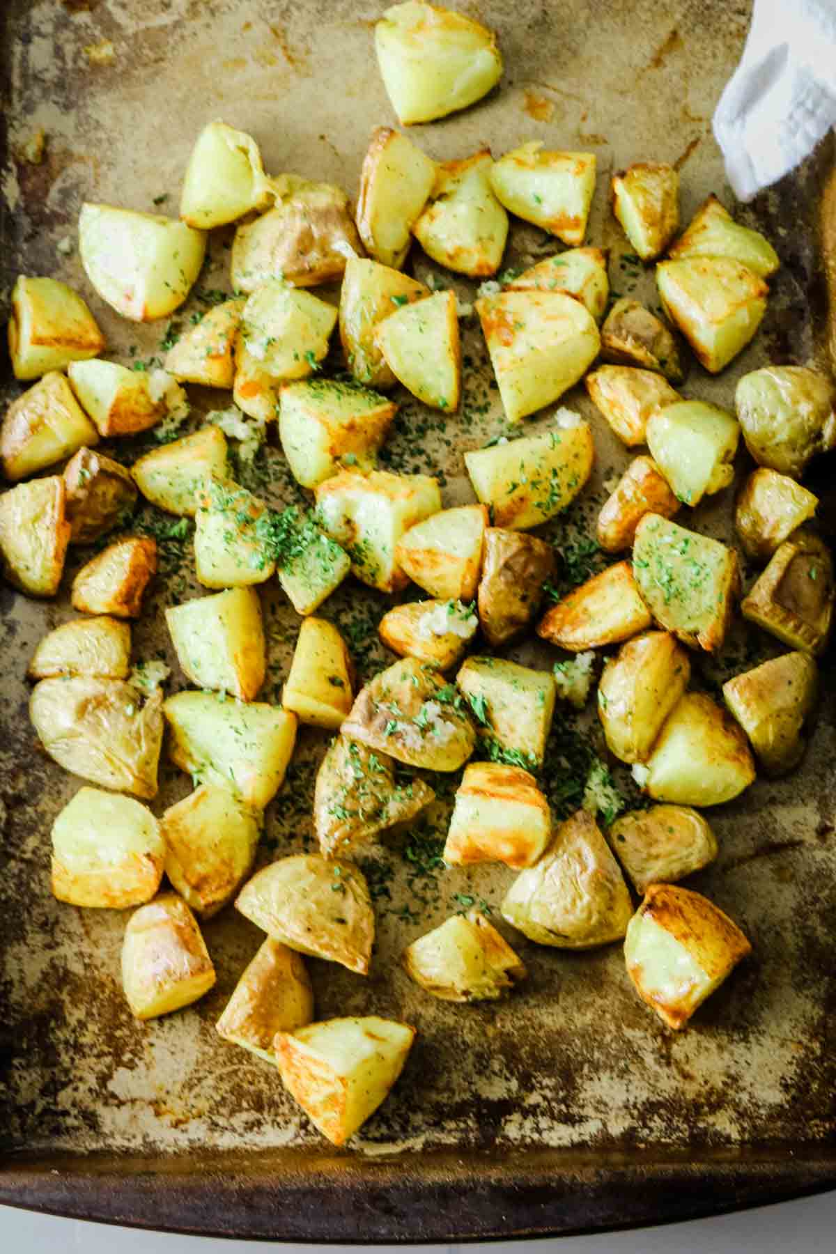 Add garlic and parsley to roasted potatoes.