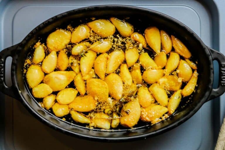 garlic cloves in baking dish in olive oil.