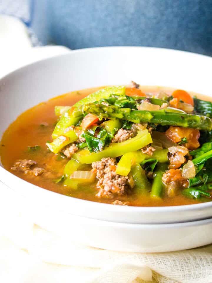 beef and vegetable soup in white bowl