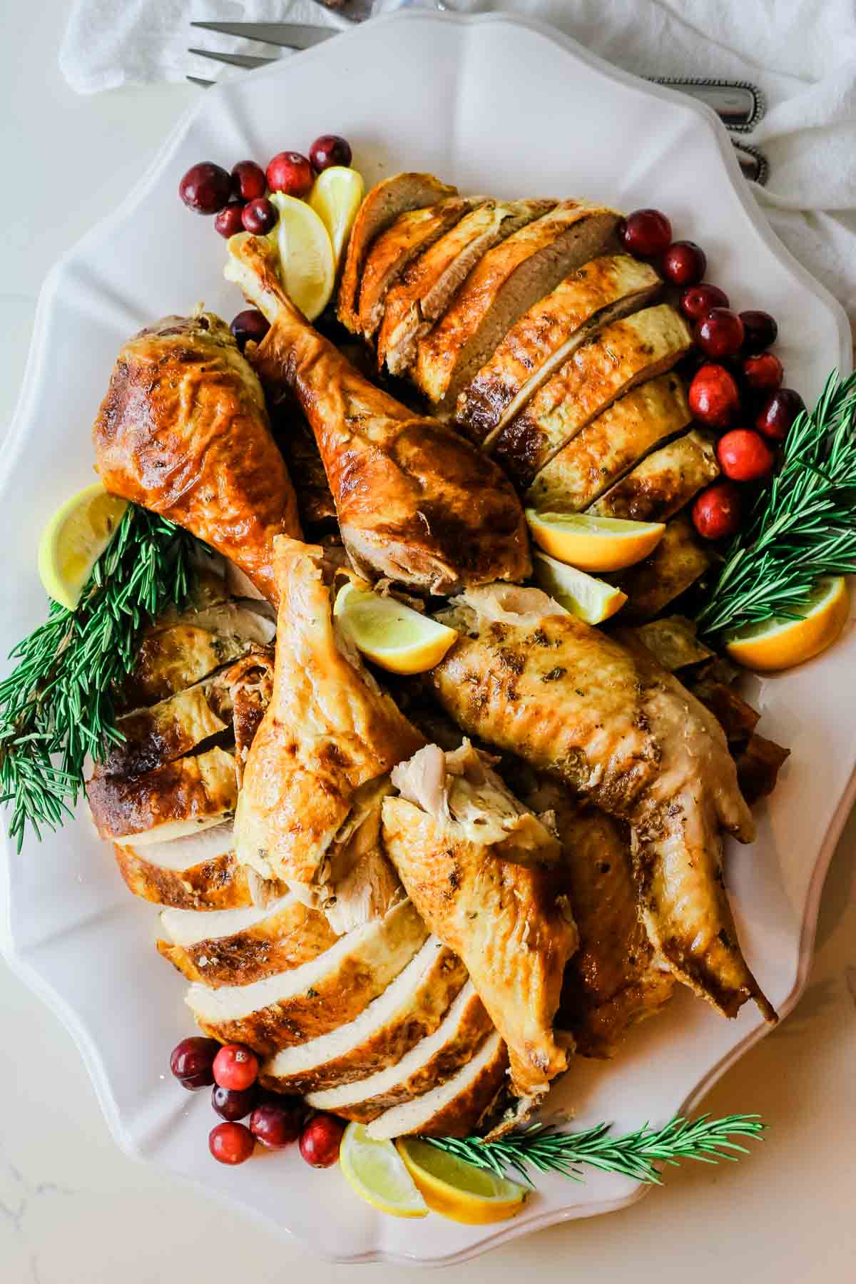 carved turkey with cranberries and rosemary sprigs