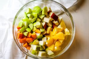 ingredients for fall fruit salad in clear bowl.