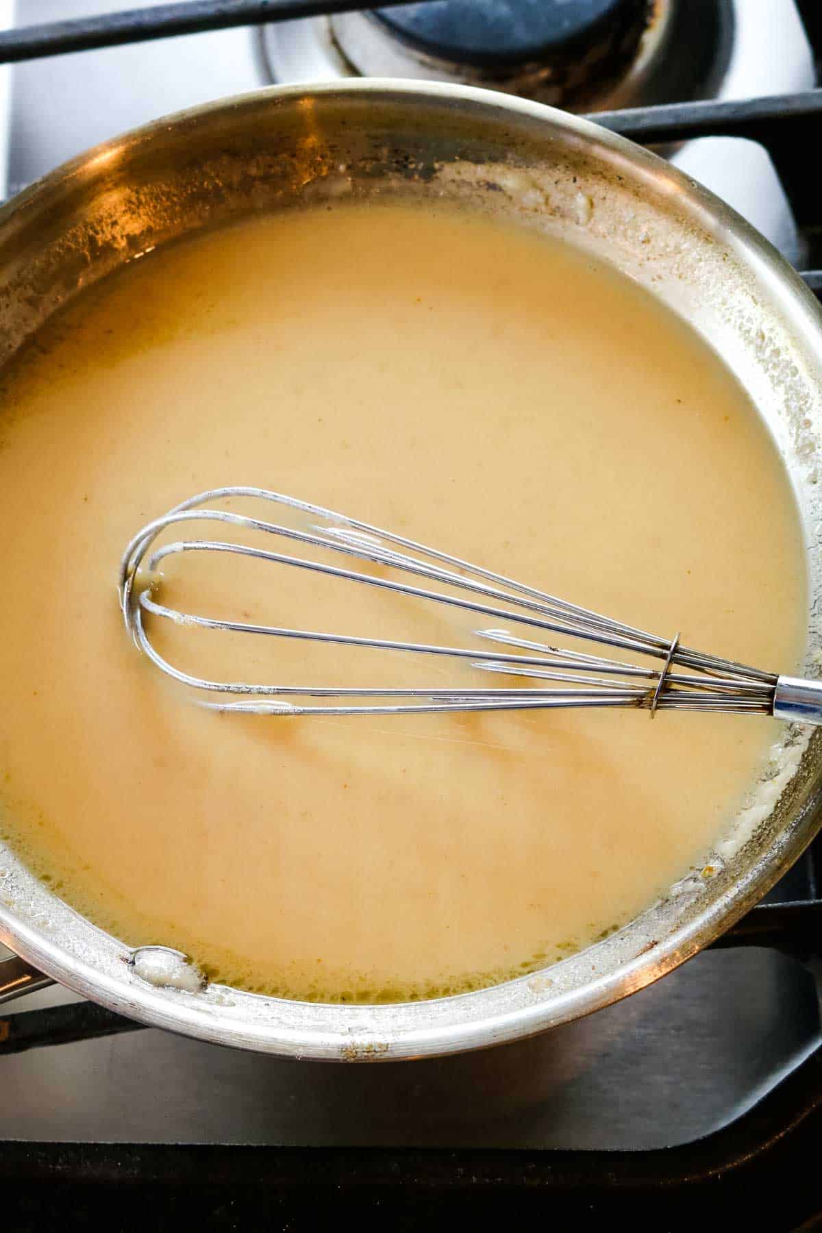 Air fryer duck gravy in a stainless pan.