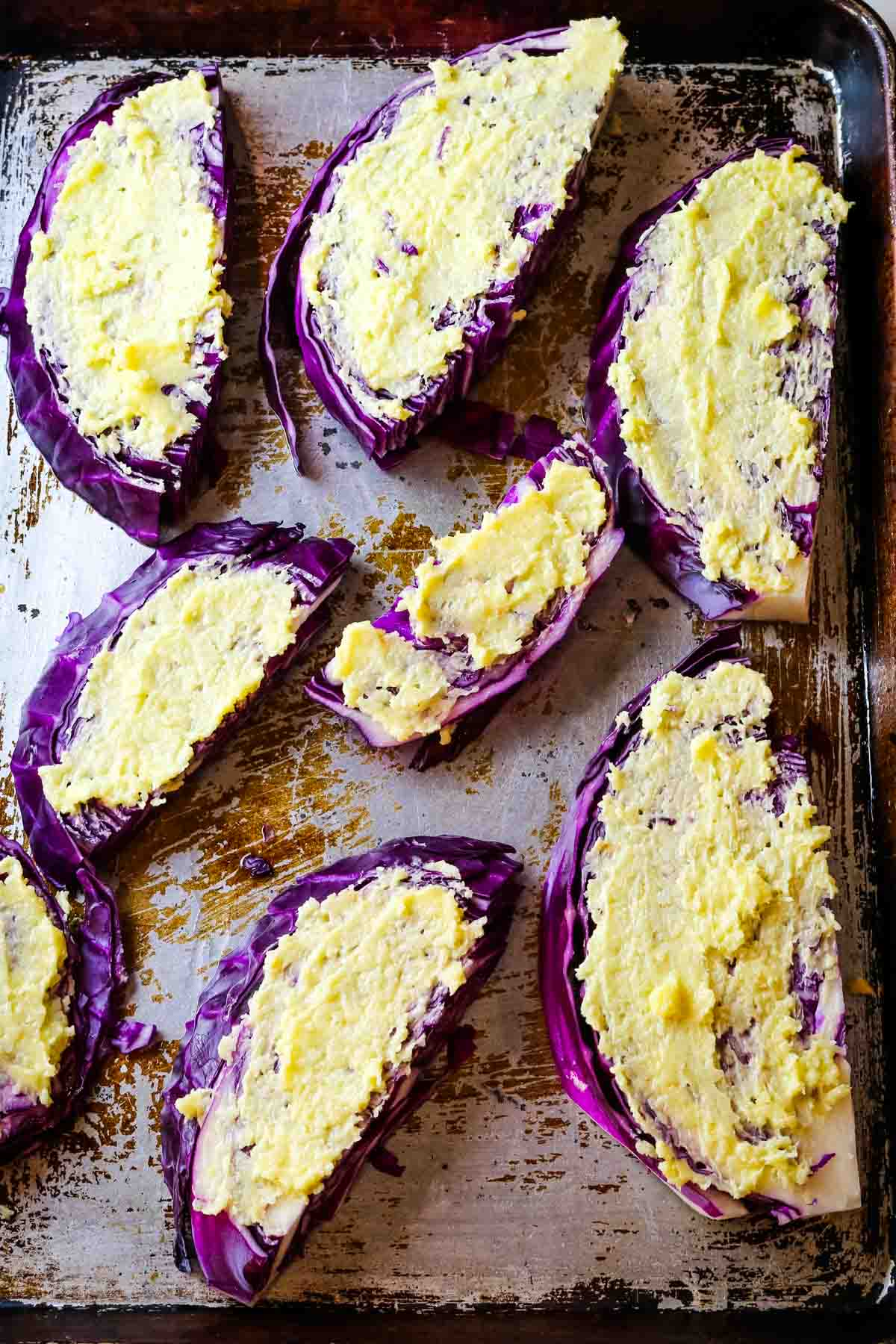 red cabbage wedges with garlic butter on top of sheet.