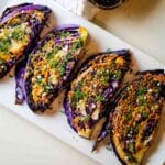 Roasted purple cabbage with dill and garlic on white platter.