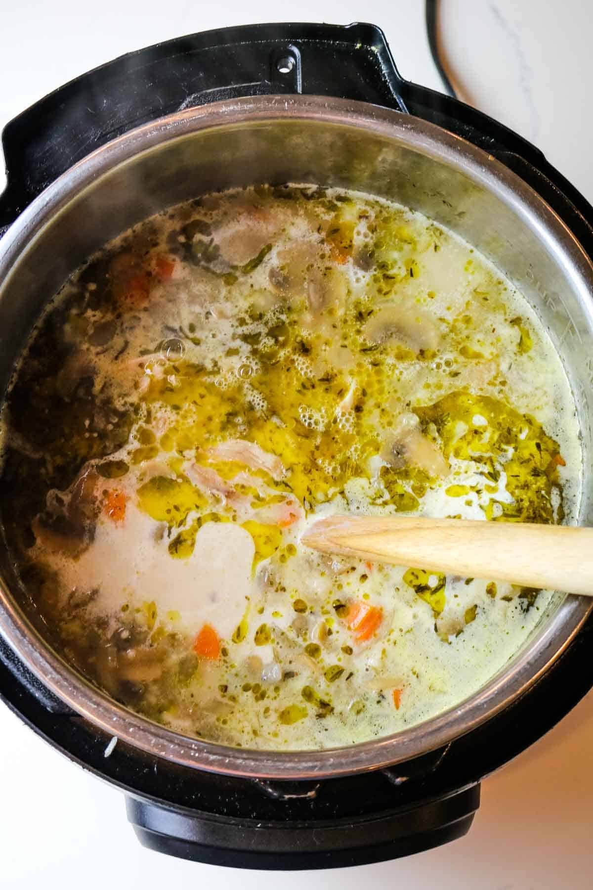 adding creamy slurry to instant pot with spoon.