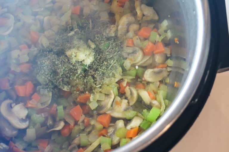 adding mushrooms and garlic and herbs to veggies.