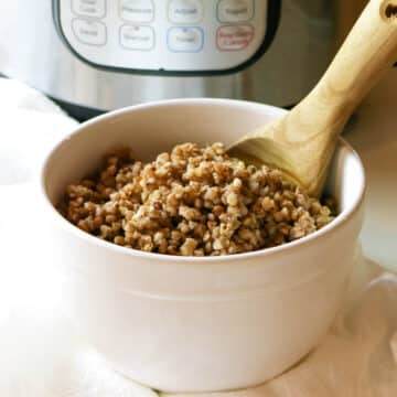 cooked buckwheat in a white bowl with Instant Pot in background