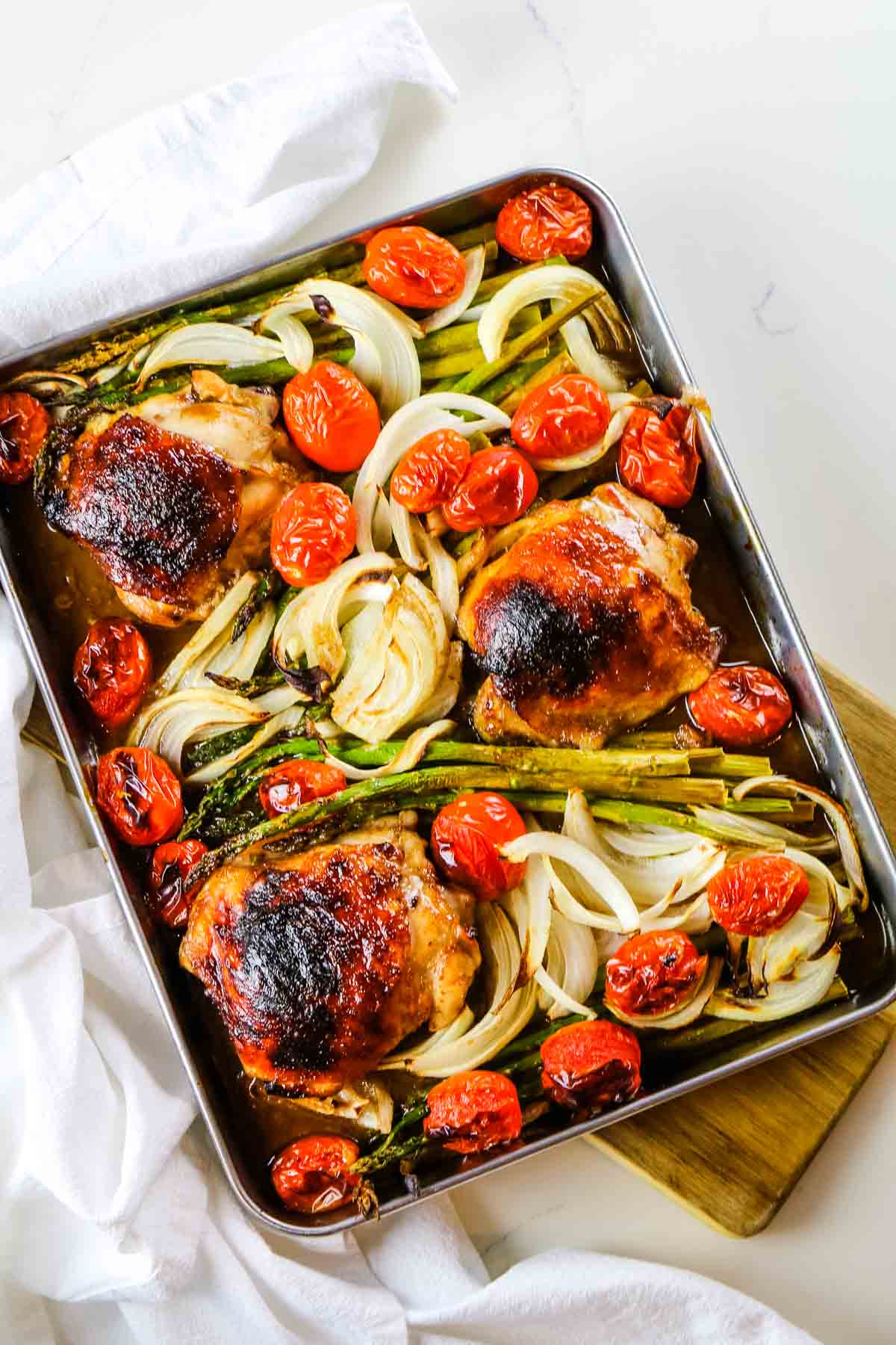 overhead picture of chicken and veggies on sheet pan.