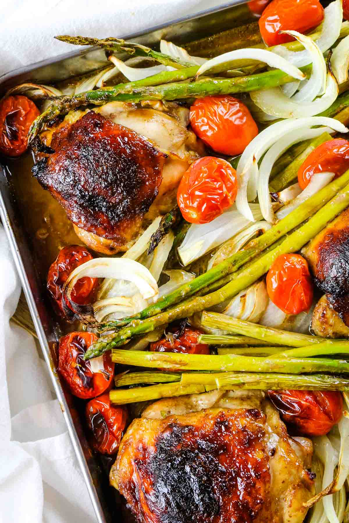baked balsamic chicken with asparagus, onions, and grape tomatoes.