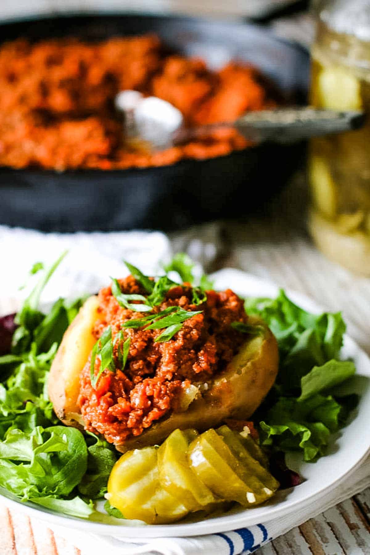 Sloppy joes on sweet potatoes with pickles.