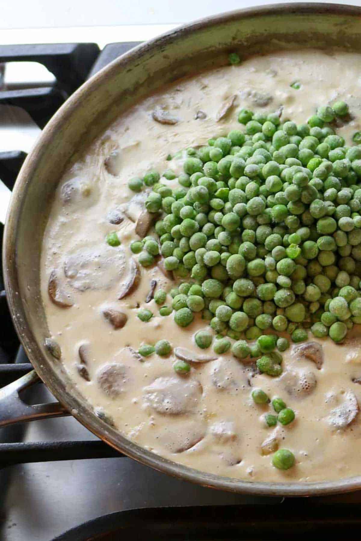 creamy mixture with mushrooms and peas added on top.