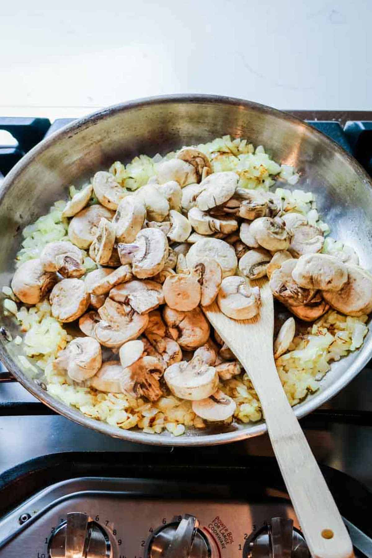 onions and mushrooms sauteed in stainless steel skillet.