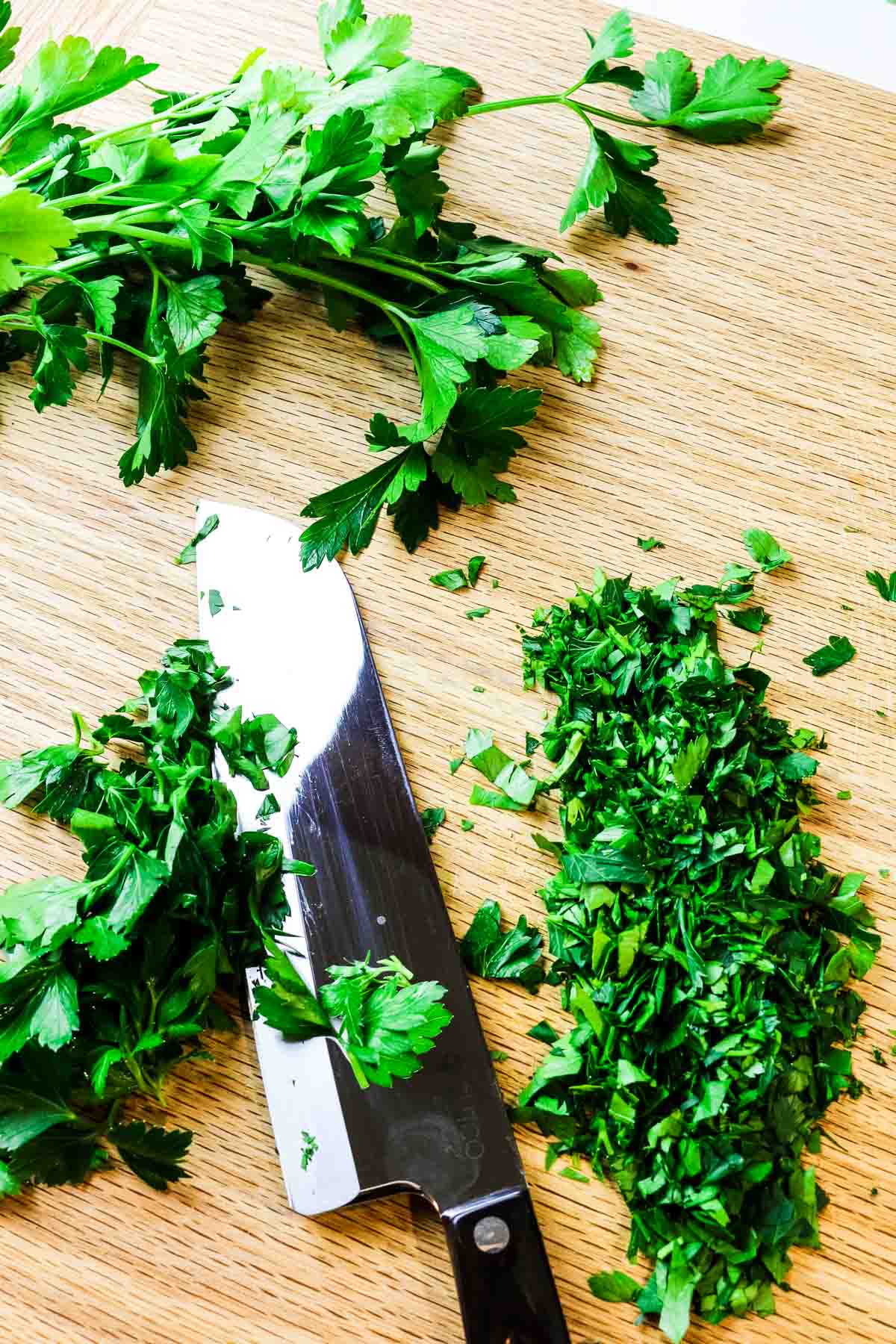 fresh chopped parsley with knife on cutting board to substitute with dried parsley