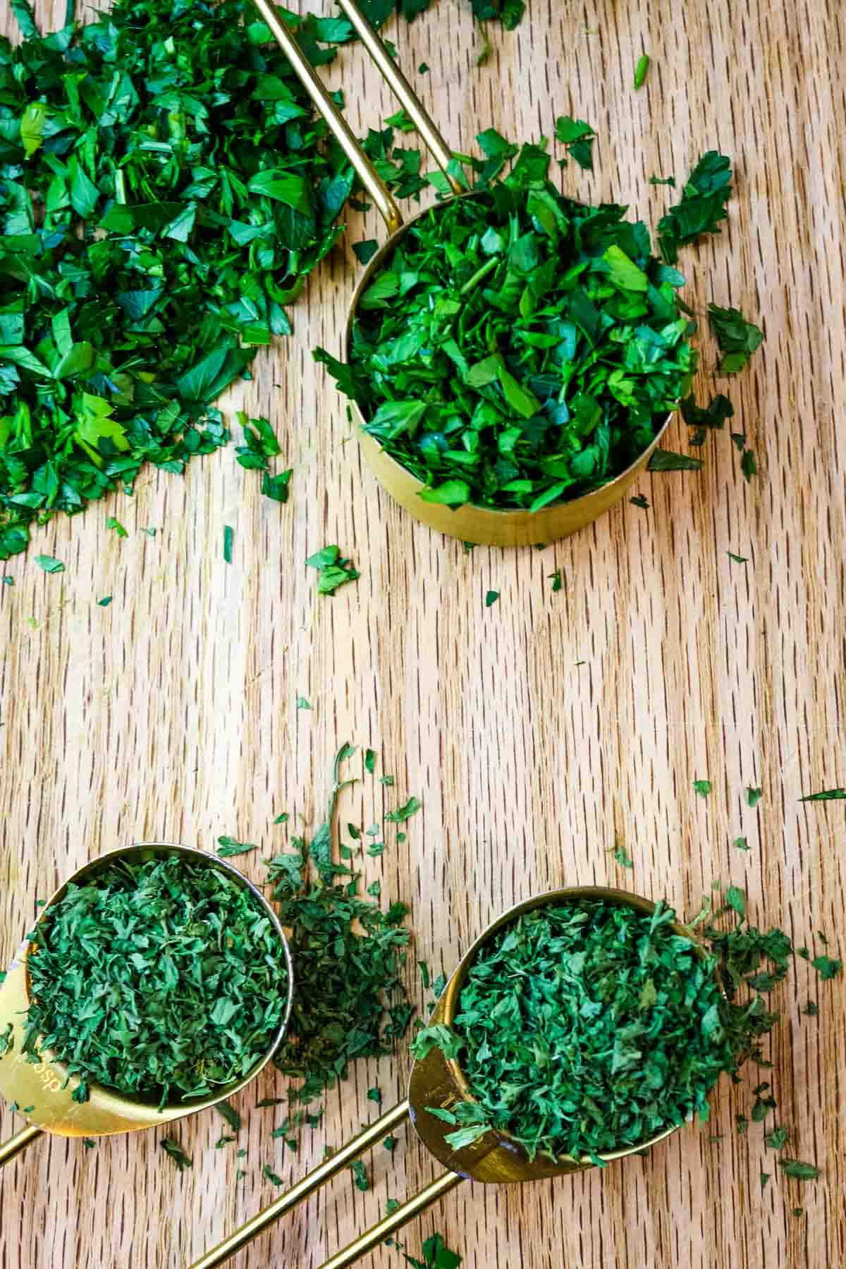 Fresh and dried parsley in measuring cups and spoons.