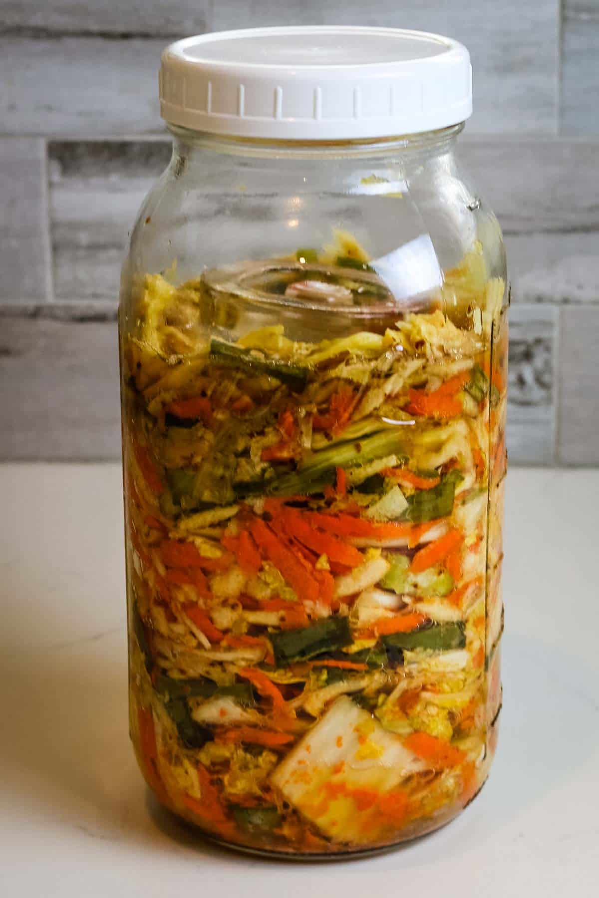 Kimchi in a tall mason jar.