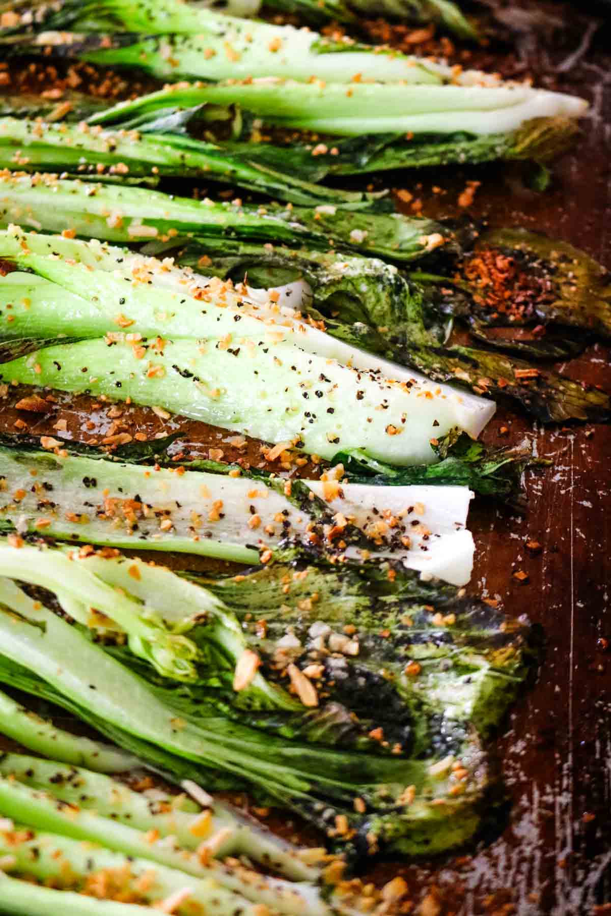 Roasted bok choy in air fryer on a baking sheet.
