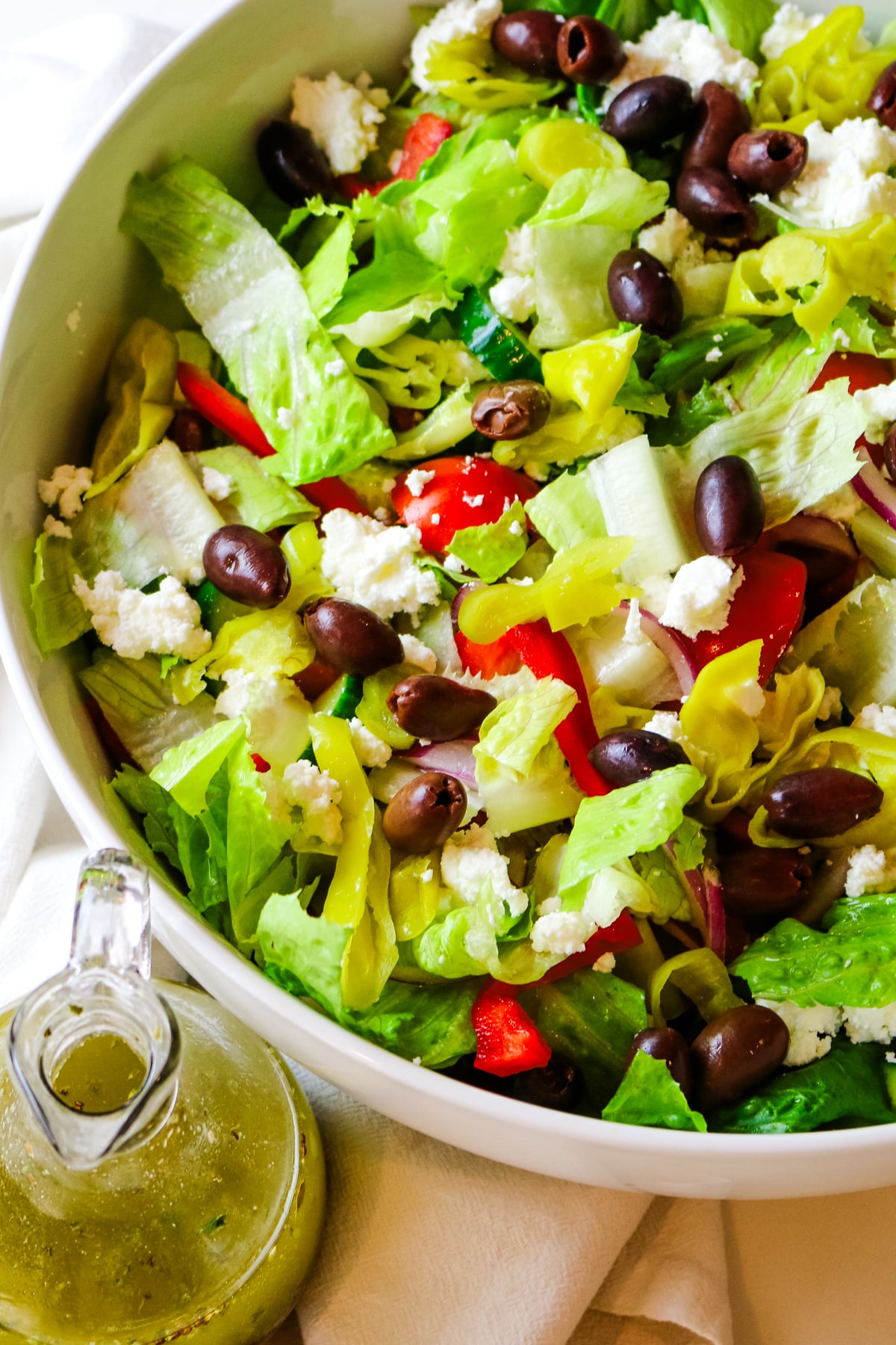 chopped Italian salad with olives and cheese and salad dressing on the left bottom corner.