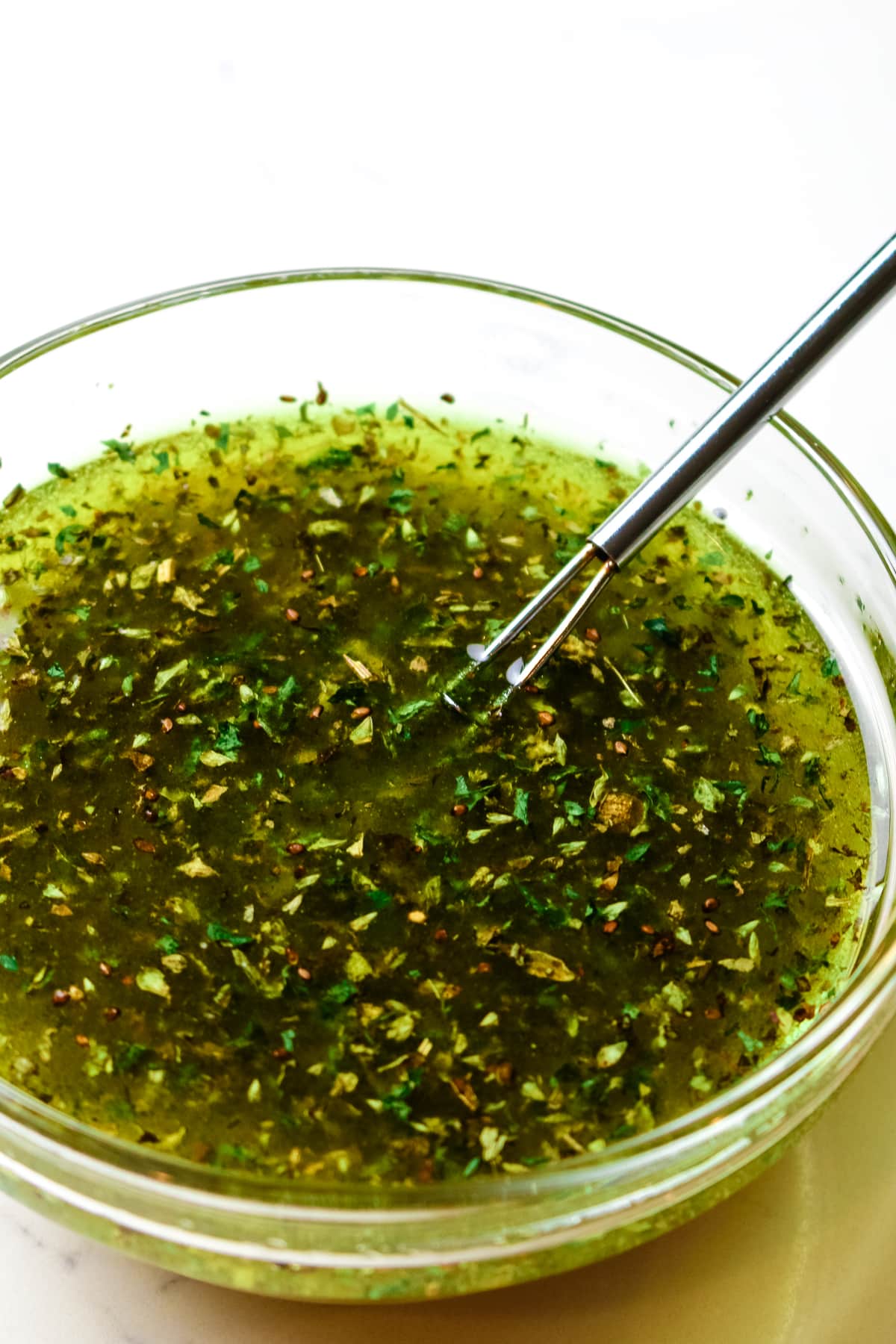 whisked salad dressing in a clear dish.