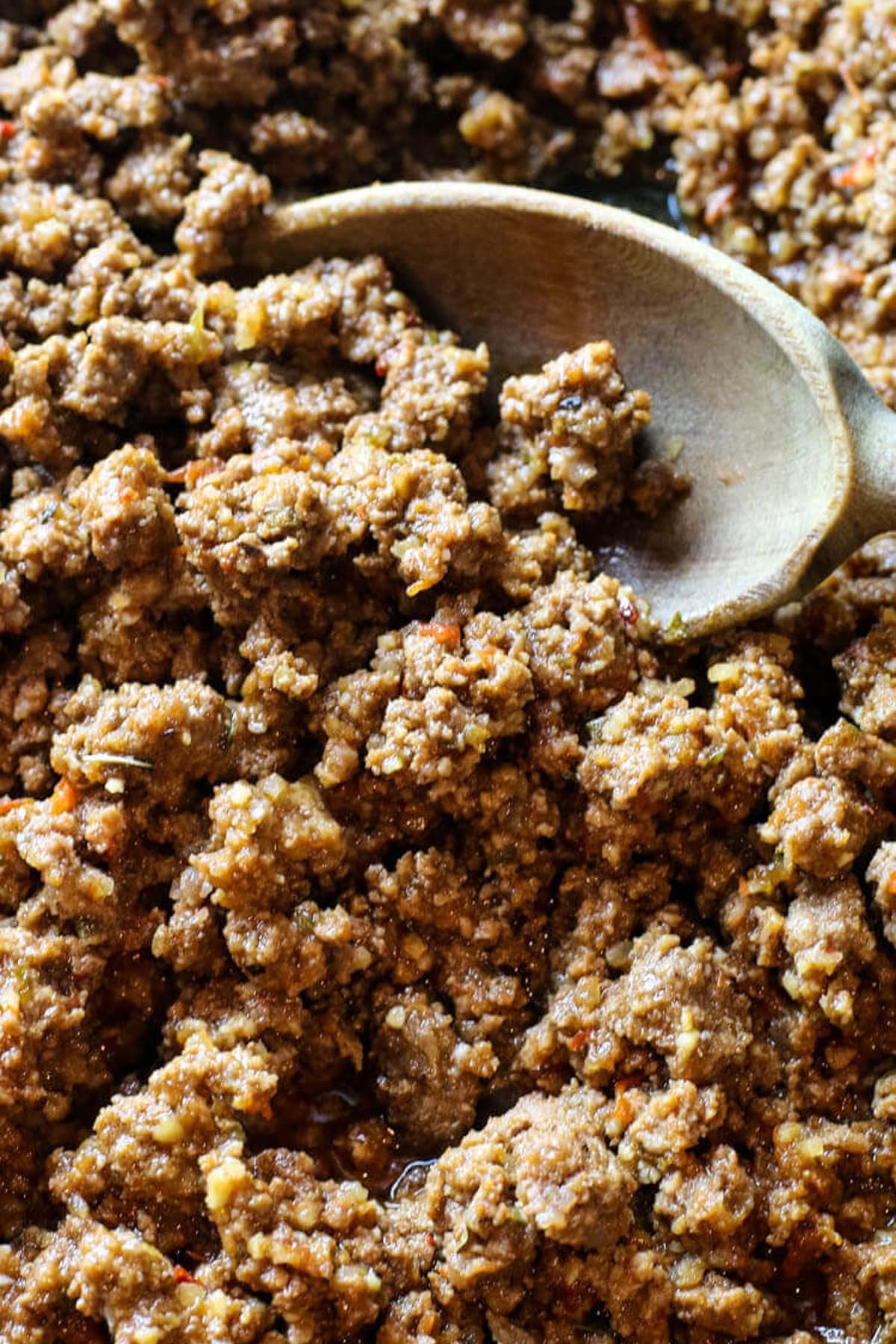 closeup of ground beef and a wooden spoon.