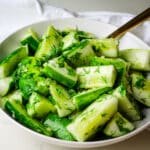 garlic cucumber dill salad in a white bowl.
