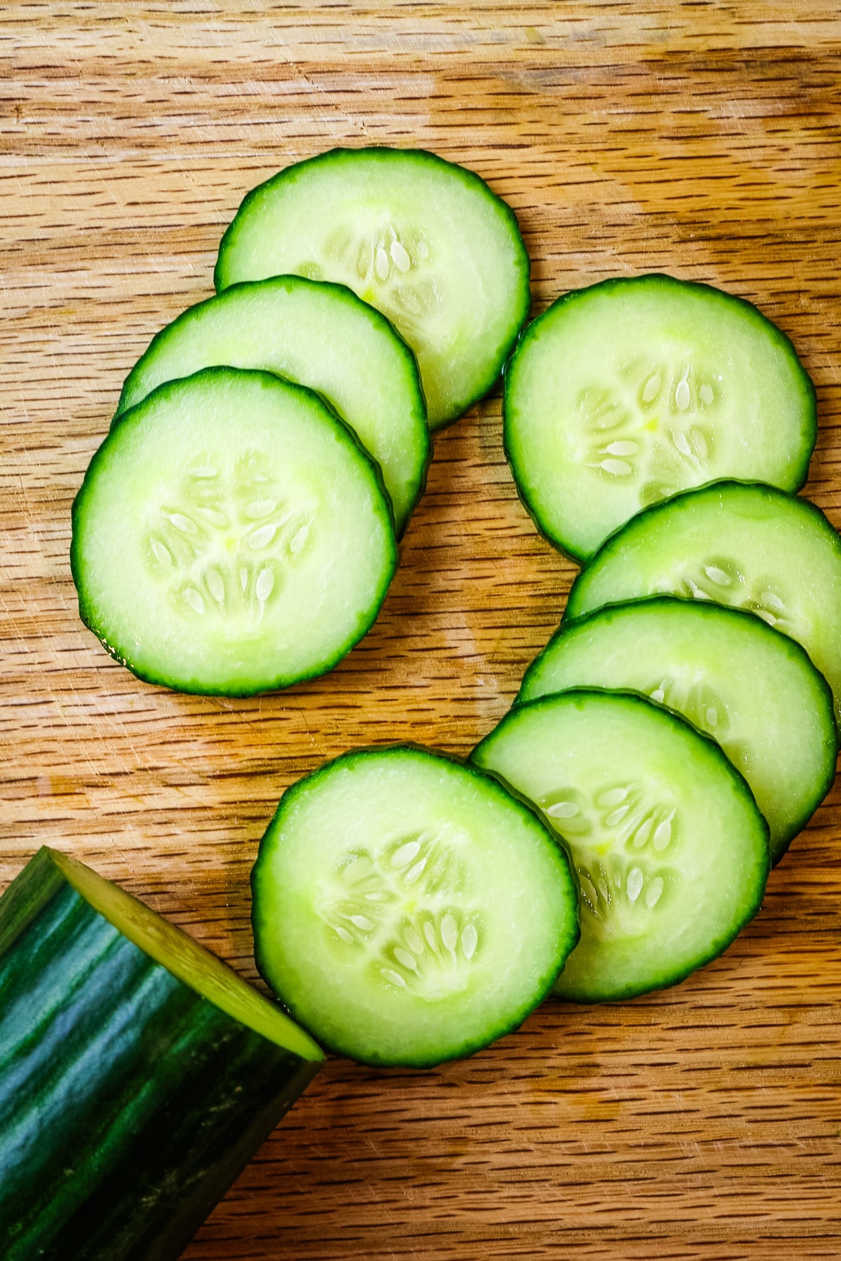 cucumber slices on wooden cutting board.