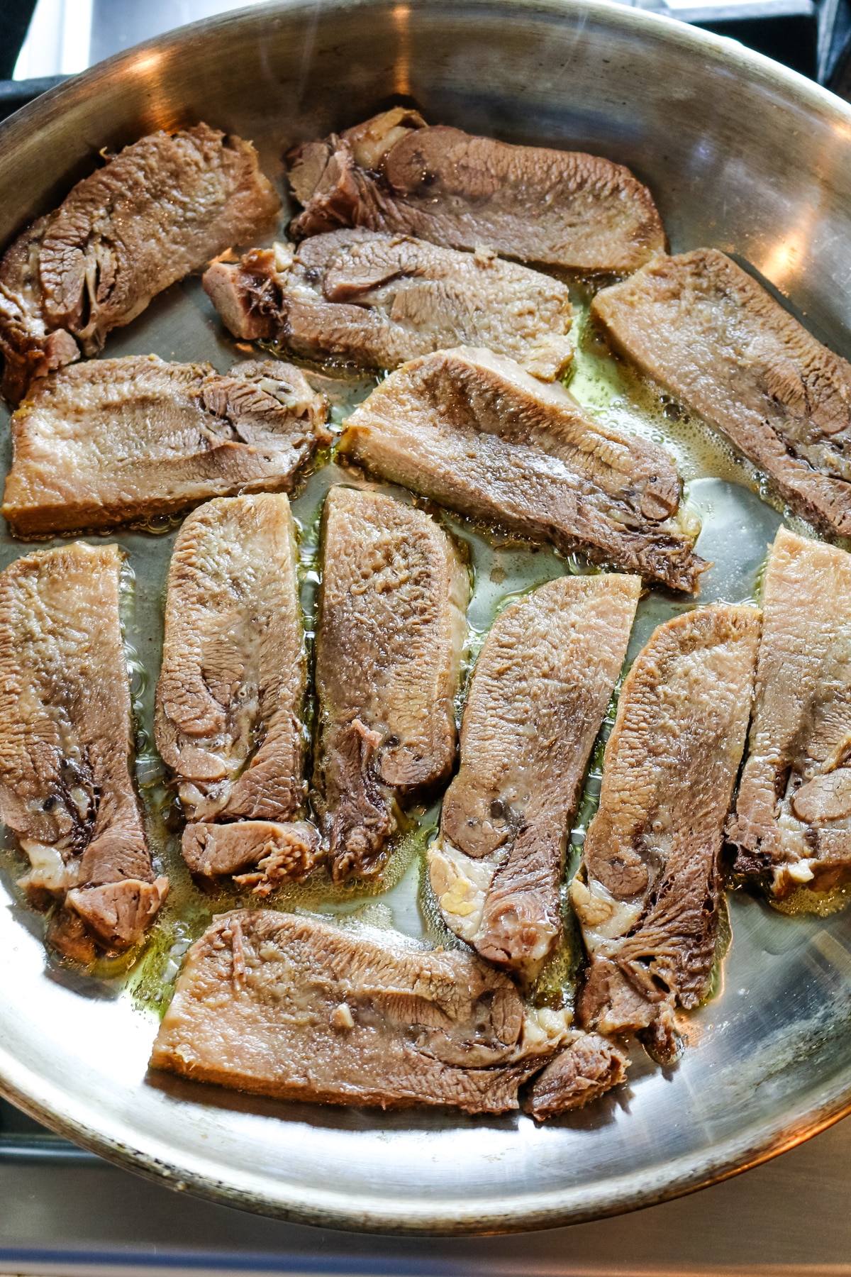 fried beef tongue on a skillet with butter.