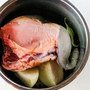 beef tongue with onions and bay leaves in instant pot inner pot.