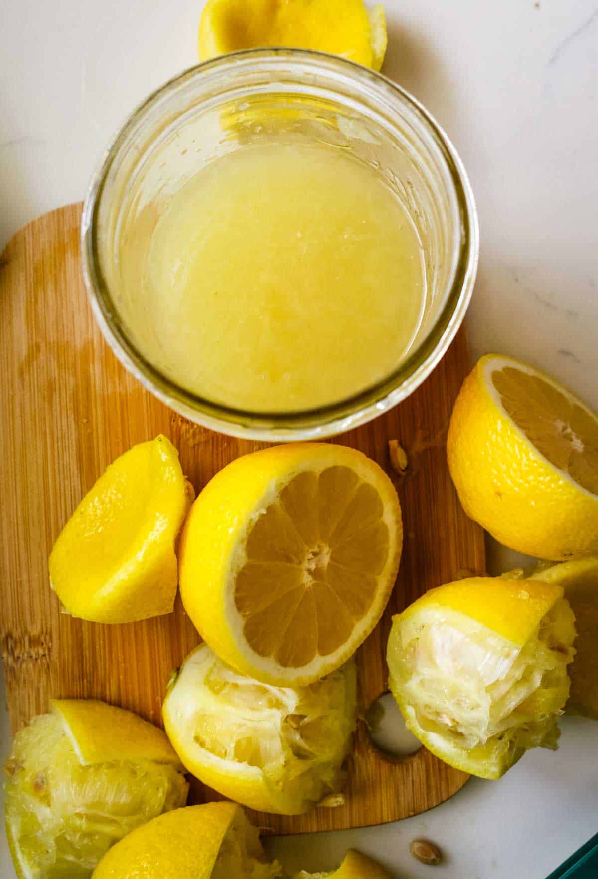 freshly squeezed lemon juice in a mason jar with lemon scraps to the side.