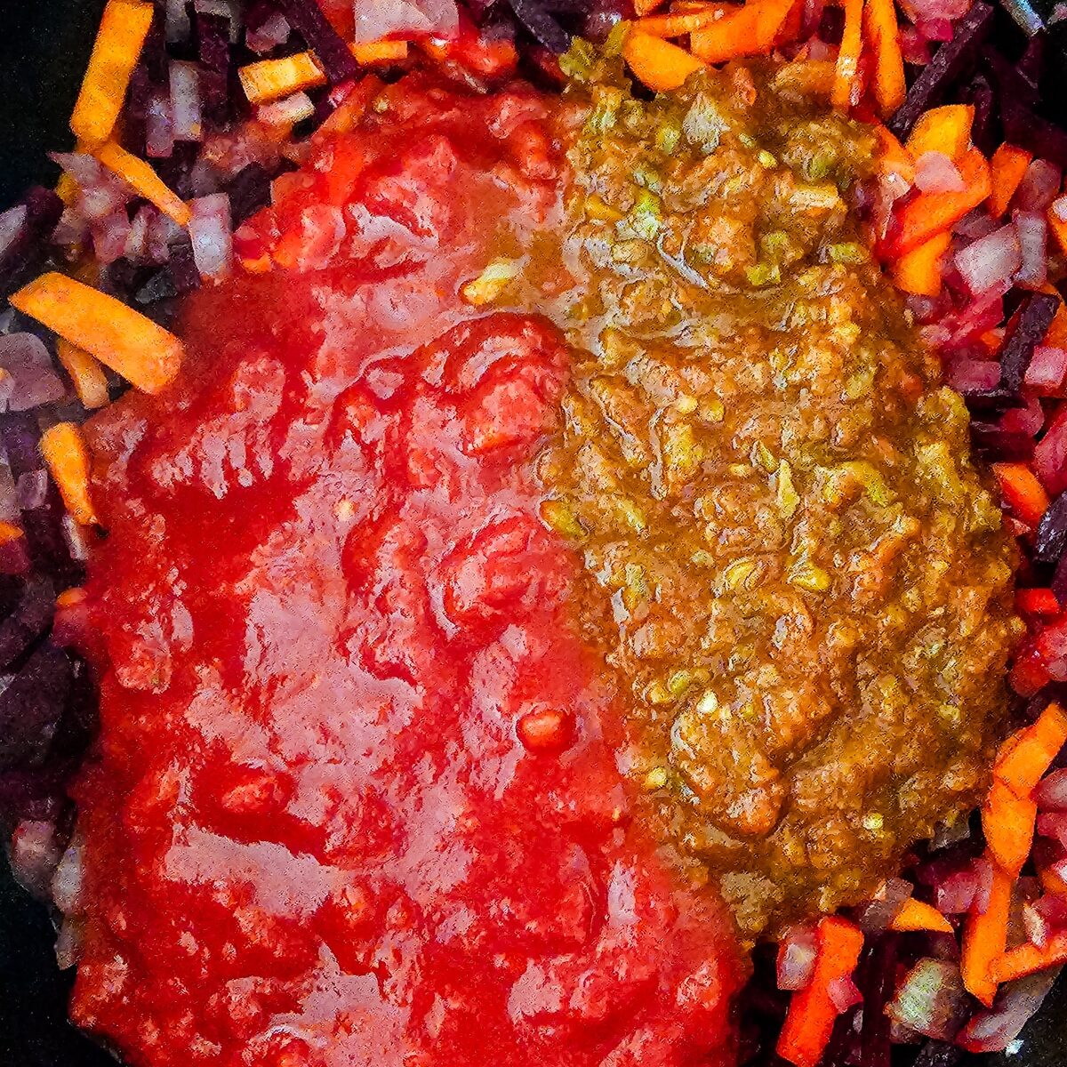 crushed tomatoes and tomato salsa added to sauteed vegetables in a pot.