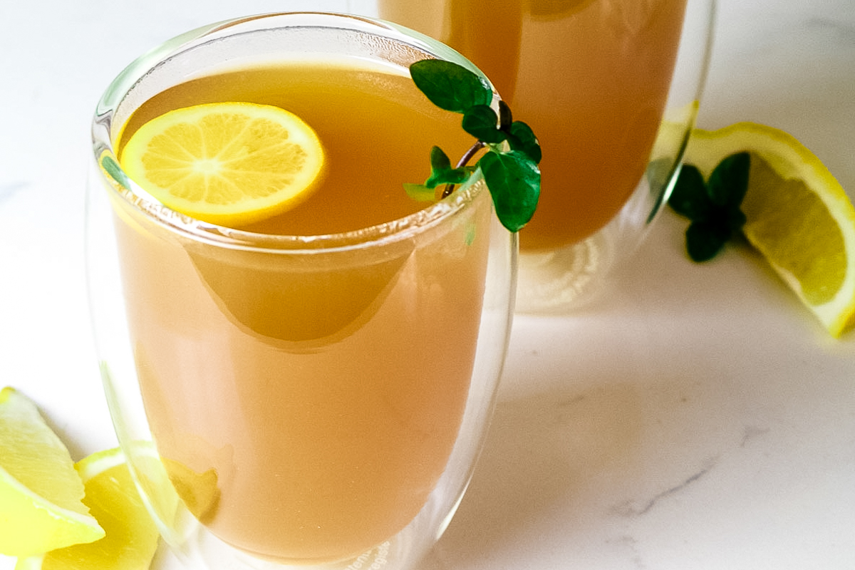 closeup of honey citrus mint tea with peppermint garnish and lemon slice.