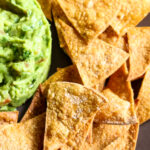 tortilla chips with salt flakes and guacamole to the left.