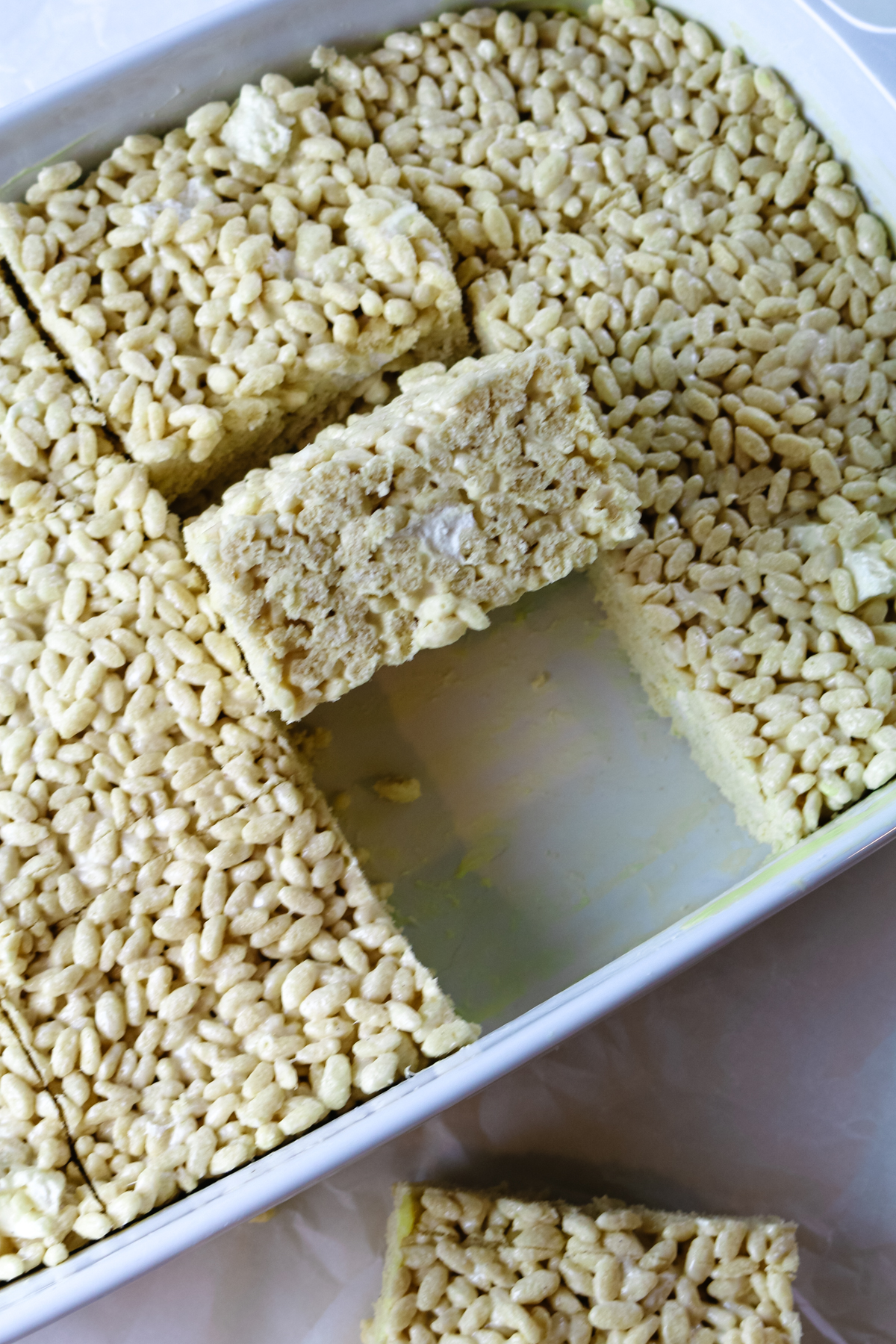 white casserole pan filled with rice crispies with one rice crispy missing.
