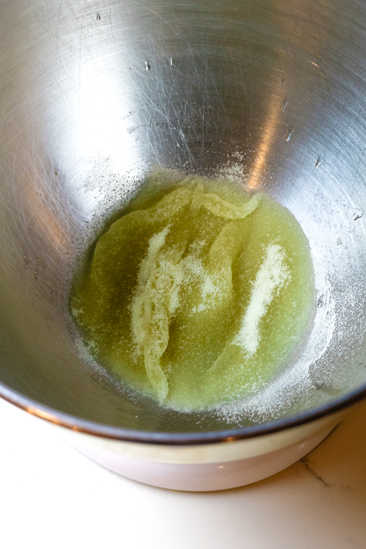 gelatin being bloomed with a bit of water in a bowl of a stand mixer.