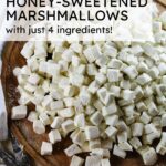honey-sweetened marshmallows cut into bite-size pieces on a cutting board with a pair of kitchen shears to the side.