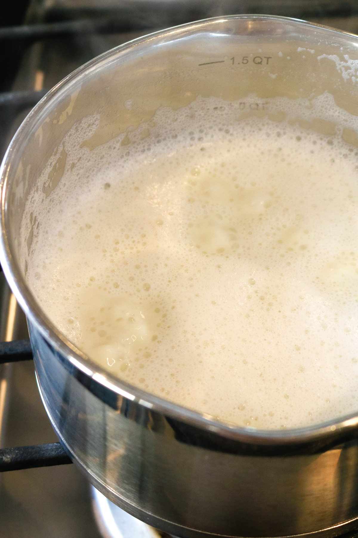 whisked milk inside of a metal pan.