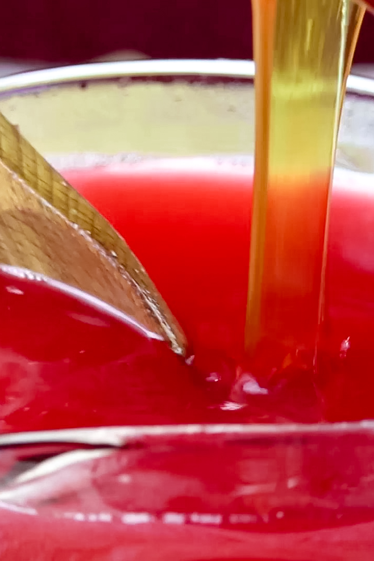 honey poured into cranberry juice to sweeten it.