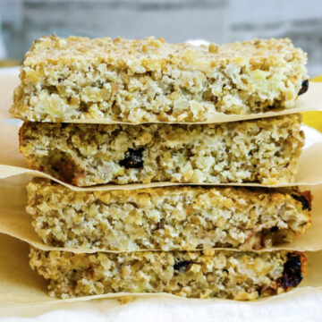 four oatmeal bars stacked on each other with parchment paper in-between all of them