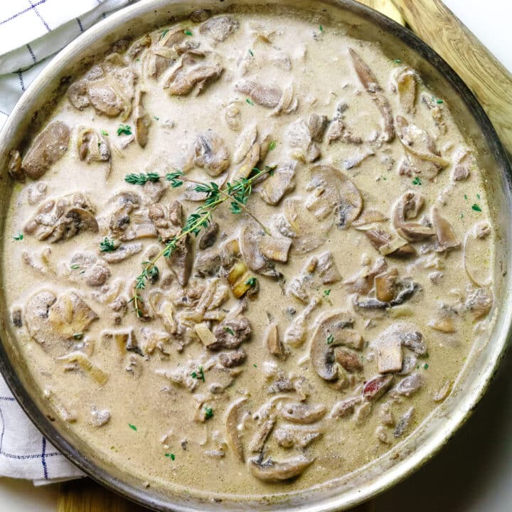 mushrooms and chicken gravy with fresh thyme sprigs garnished on top.