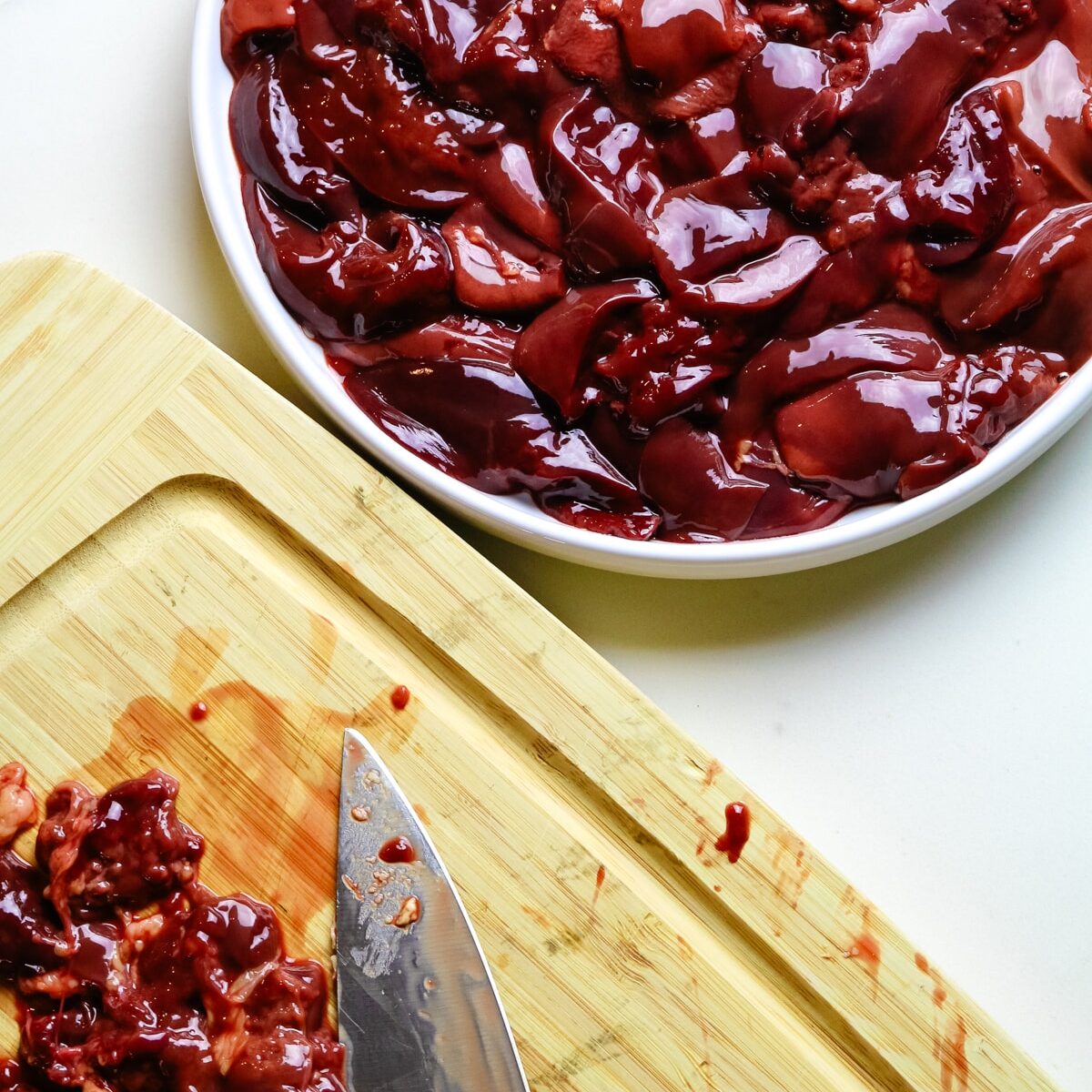 chicken livers cleaned on a wooden cutting board.