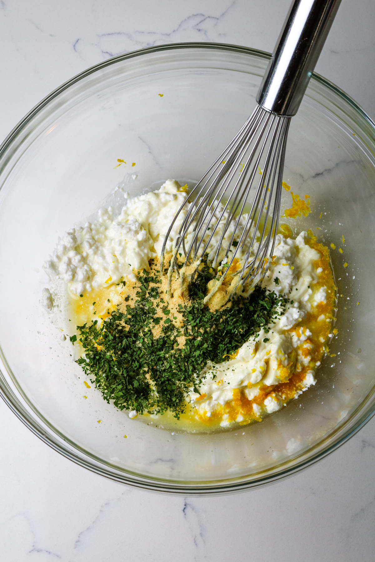 cottage cheese, lemon zest, mayo, and parsley with a whisk to the side.