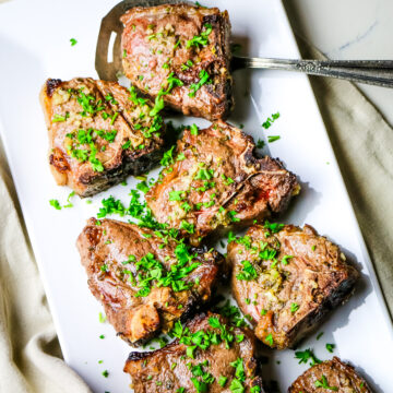 lamb loin chops air fried on a white square platter.
