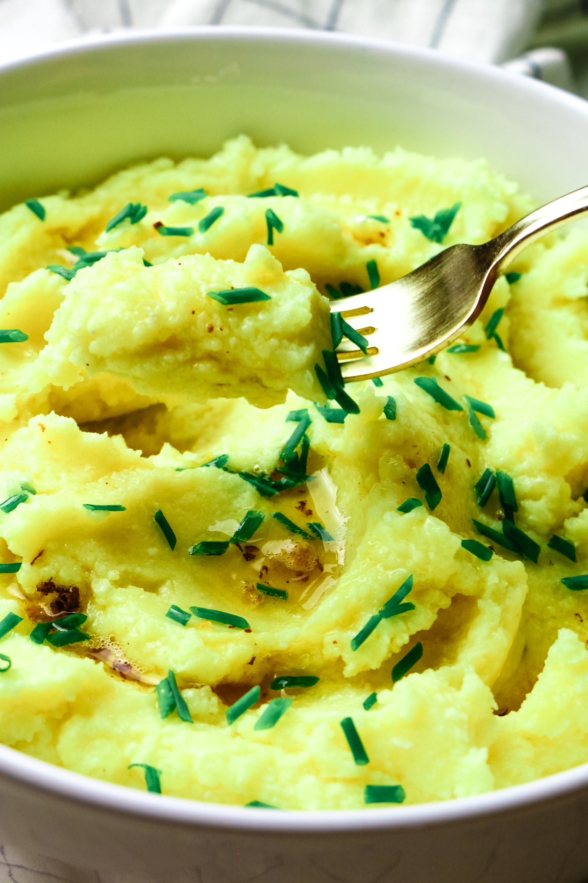 mashed potatoes with fresh chives and a fork.