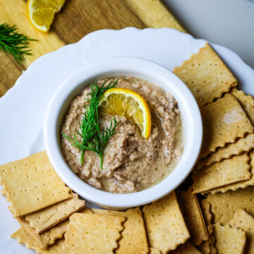 cod liver pate in a white ramekin with crackers on the side.